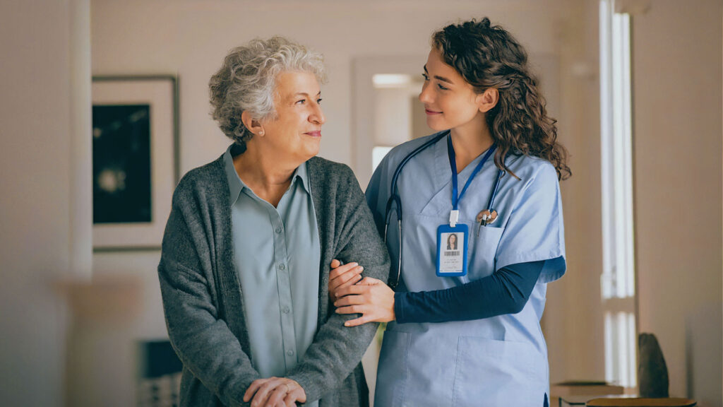 Senior woman receiving assistance from a healthcare professional in a care home setting