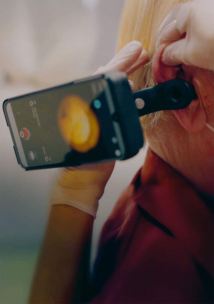 Clinician using Tympa Health ear assessment device with a patient